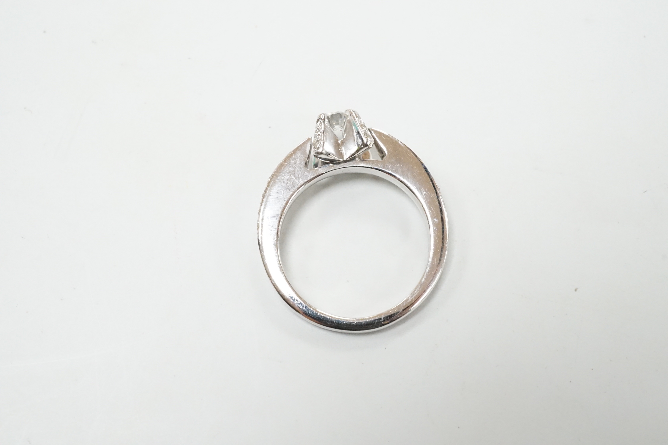 A modern 18ct white gold and claw set single stone diamond ring, with diamond chip set shoulders, size M, gross weight 5.2 grams.